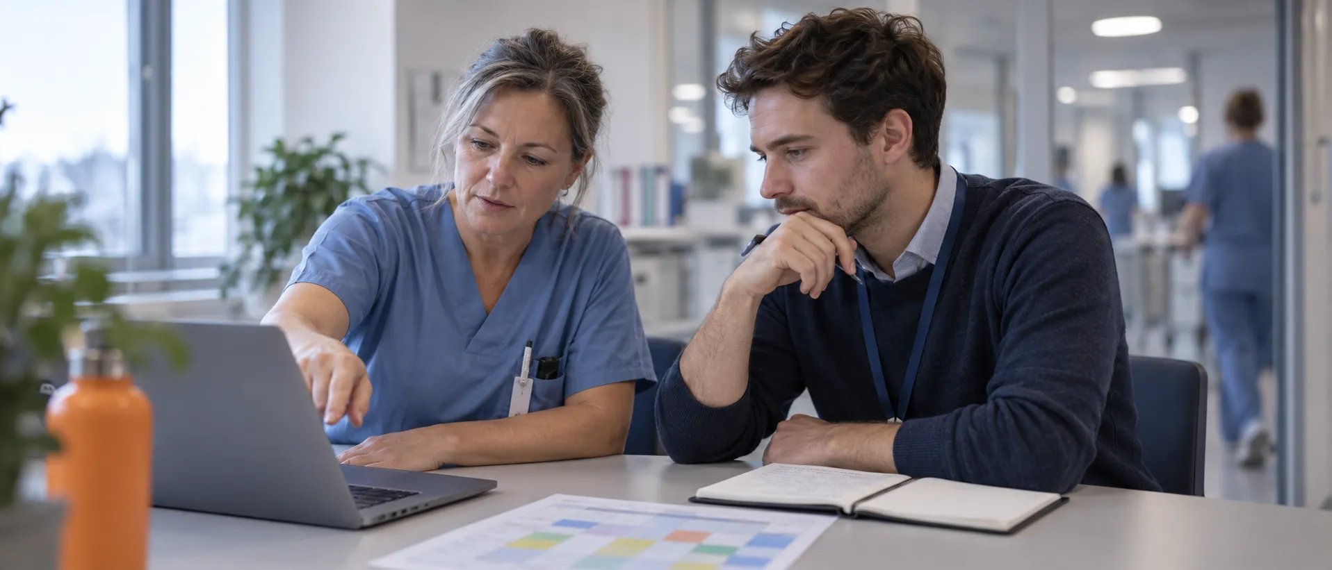 Eine Pflegefachperson zeigt einem Mitarbeiter des inplan-Teams am Laptop, wie ihre Station plant